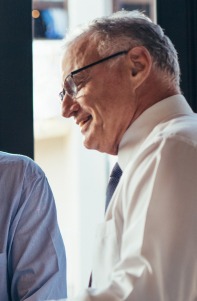 Two businessmen smiling while looking at a laptop