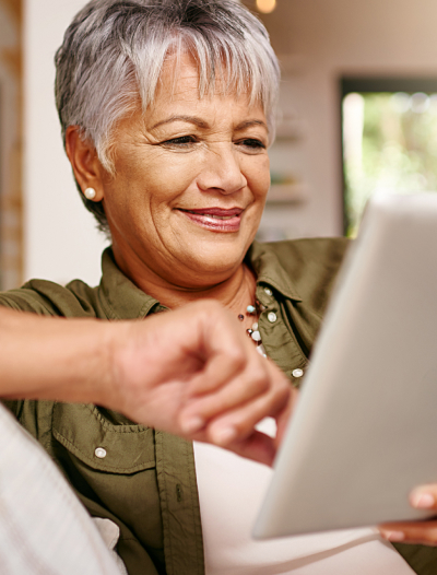 Mature woman smiling while using a tablet