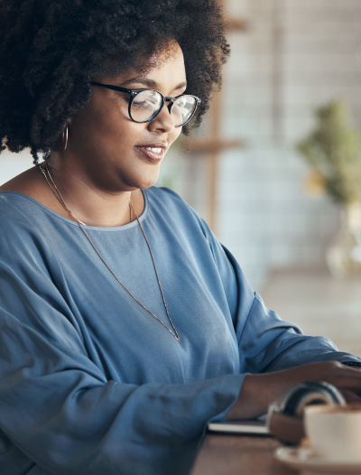 A smiling woman typing on a laptop