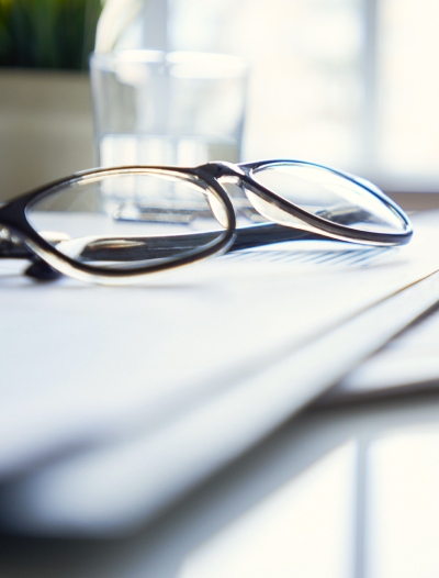 A pair of glasses on top of paperwork